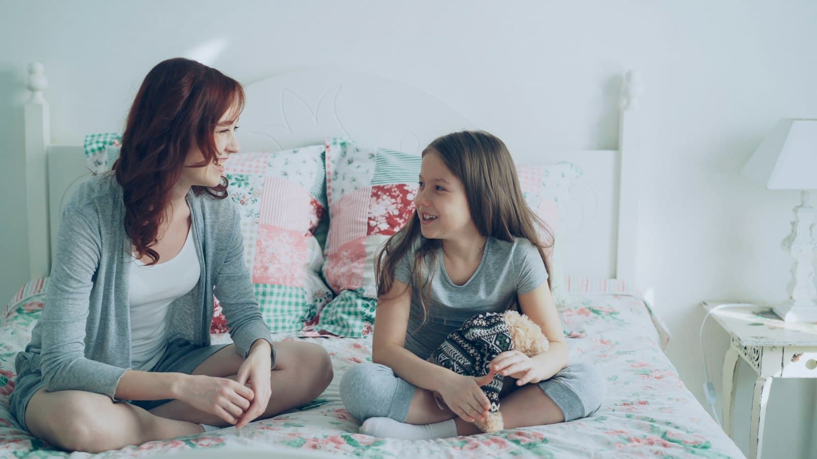 Una madre y su hija conversan sentadas, en un momento de confianza
